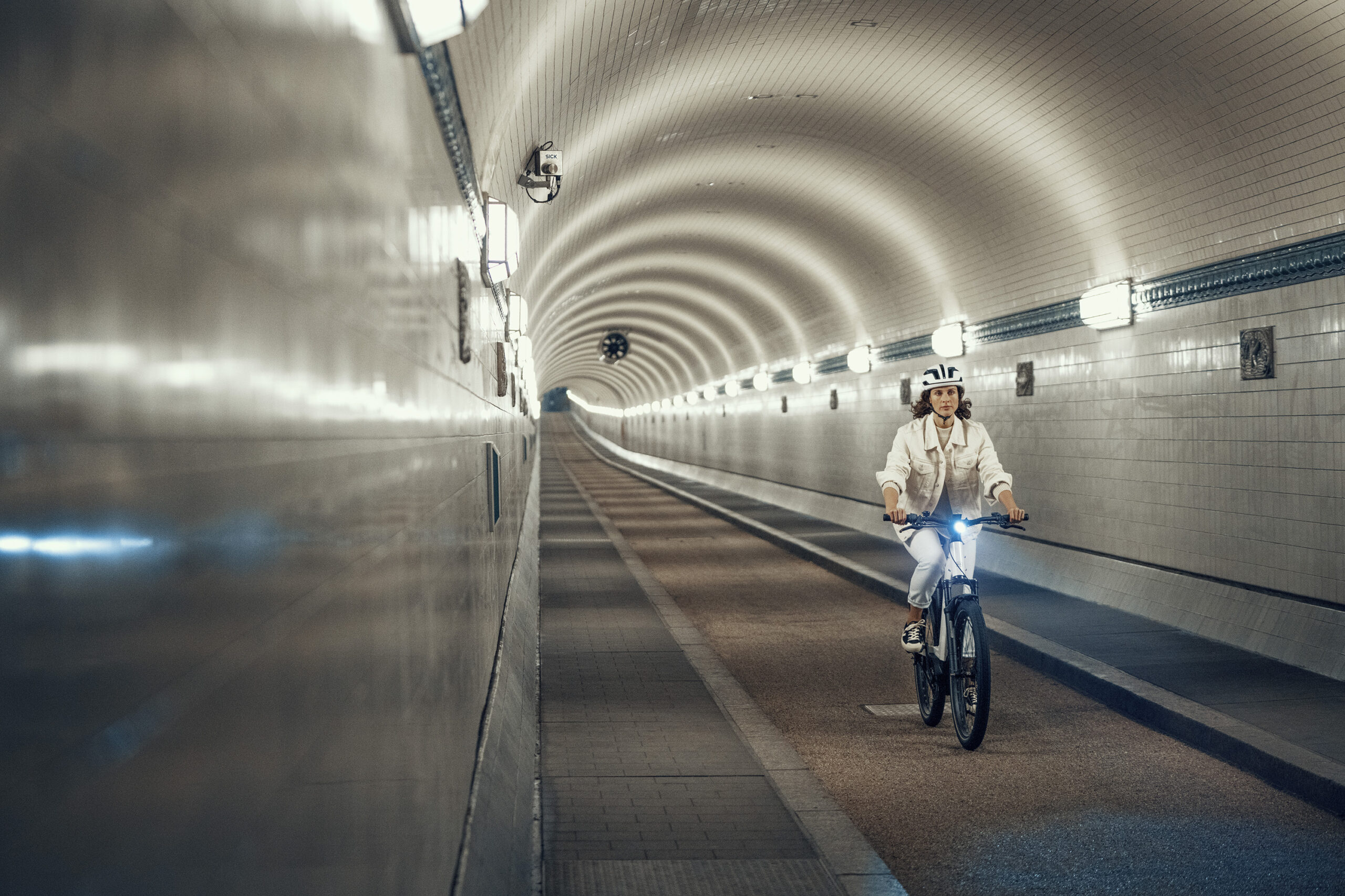 A girl is riding an ebike in a tunnel