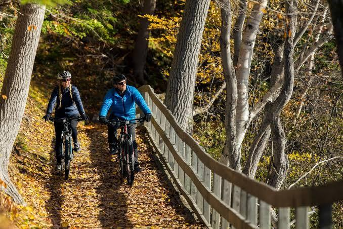 A couple is riding electric bikes on a rough road in cape breton highlands national park