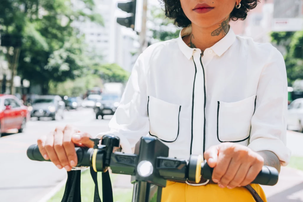 A girl waring white shirt and yellow pants is riding her ebike with a light
