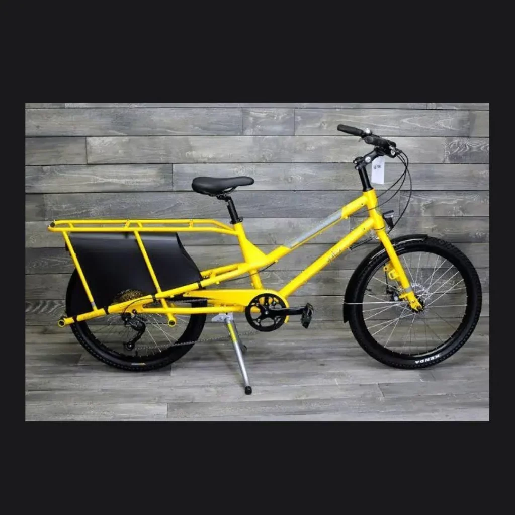 A yellow electric bike with a troch light on the front.
