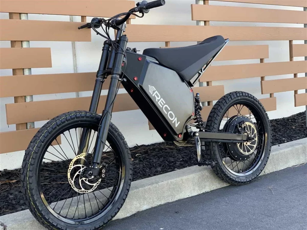 A black electric bike parked against a wall.